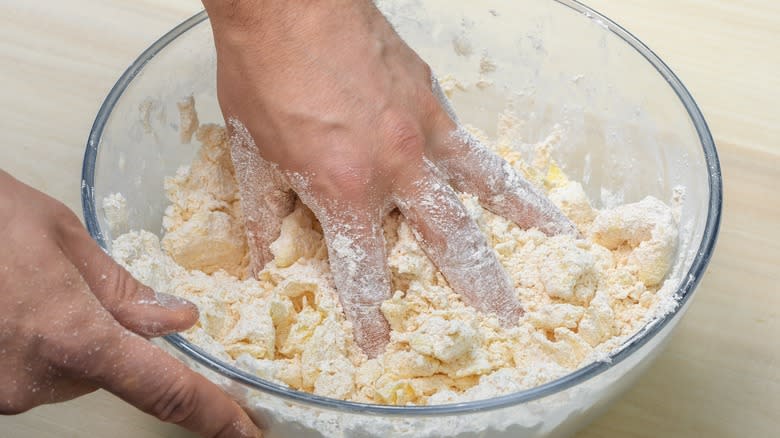 Hand with dough in bowl