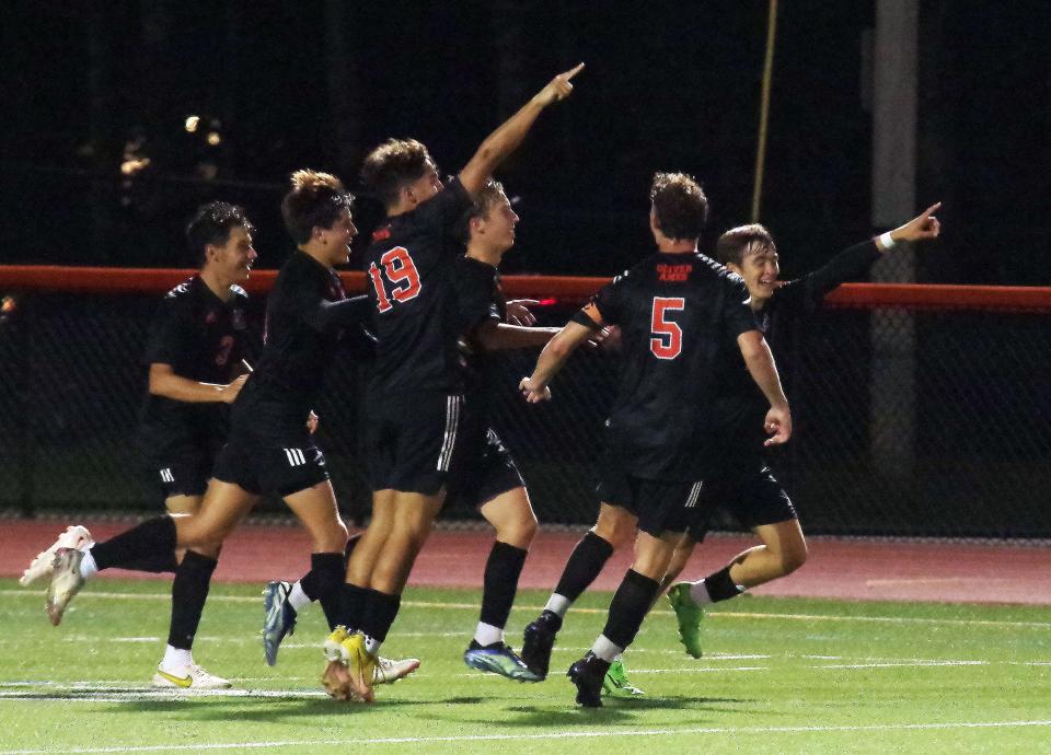 Oliver Ames Sophmore Luke Churchill (in between #19 and #5) celebrates with his Tiger teammate after scoring a goal late in the first half, breaking a scorless deadlock on Monday, Sept. 12, 2022.