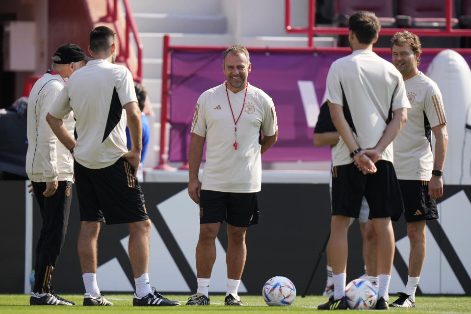 Germany's head coach Hansi Flick, center=, is surrounded by his assistants prior to a training session at the Al-Shamal stadium on the eve of the group E World Cup soccer match between Germany and Japan, in Al-Ruwais, Qatar, Tuesday, Nov. 22, 2022. Germany will play the first match against Japan on Wednesday, Nov. 23. (AP Photo/Matthias Schrader)