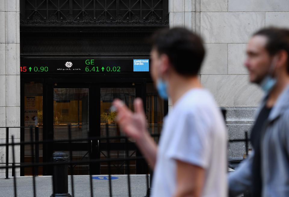 People walk by the New York Stock Exchange (NYSE) in lower Manhattan on October 5, 2020 in New York City. - Stock markets bounced back on reports suggesting Donald Trump's health had improved after his positive test for the coronavirus, with traders also cheered by signs that U.S. lawmakers were edging towards agreement on a new stimulus package. (Photo by Angela Weiss / AFP) (Photo by ANGELA WEISS/AFP via Getty Images)