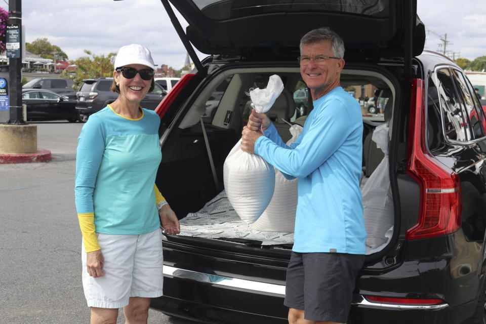 Nancy and Bob Shoemaker, whose home is next to the water, load sandbags into their car in downtown Annapolis, Md., on Friday, Sept. 22, 2022 in preparation for an approaching storm. Tropical Storm Ophelia has formed off the mid-Atlantic coast and is expected to bring heavy rain, storm surges and windy conditions over the weekend, the National Hurricane Center said. (AP Photo/Brian Witte)