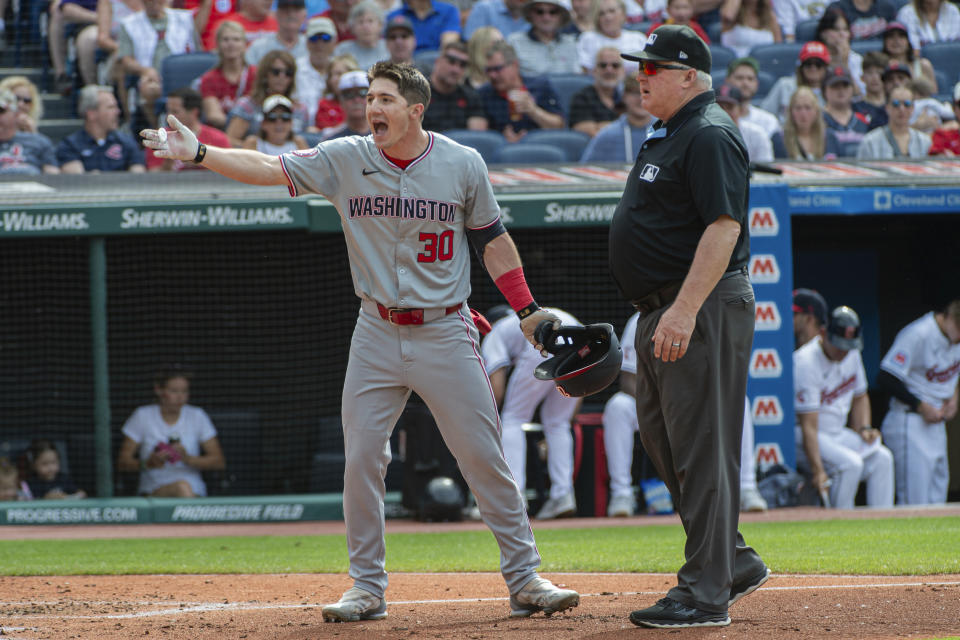 Washington Nationals' Jacob Young (30) argues a called third strike by umpire Malachi Moore (not shown) with umpire Bill Miller, right, during the third inning of a baseball game against the Cleveland Guardians in Cleveland, Saturday, June 1, 2024. (AP Photo/Phil Long)