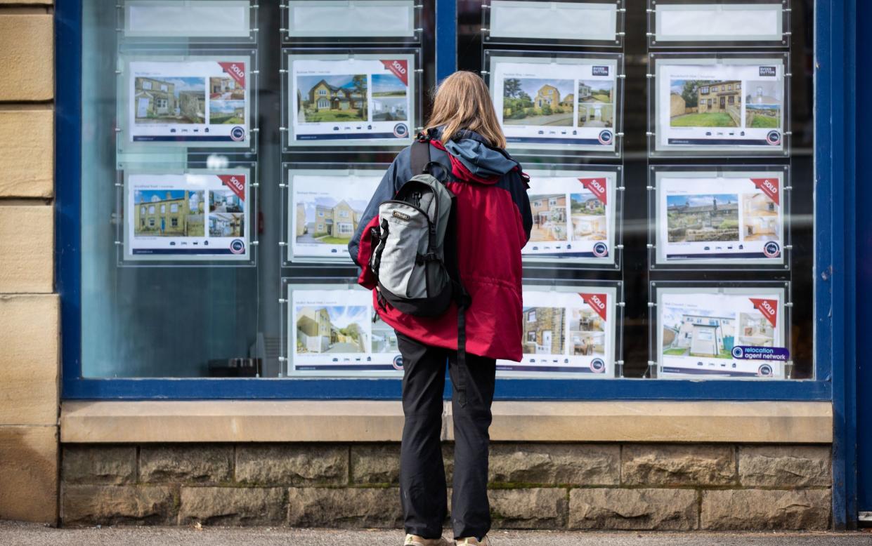 A person looks at properties in the window of an estate agent in Holmfirth, Britain - ADAM VAUGHAN/EPA-EFE/Shutterstock