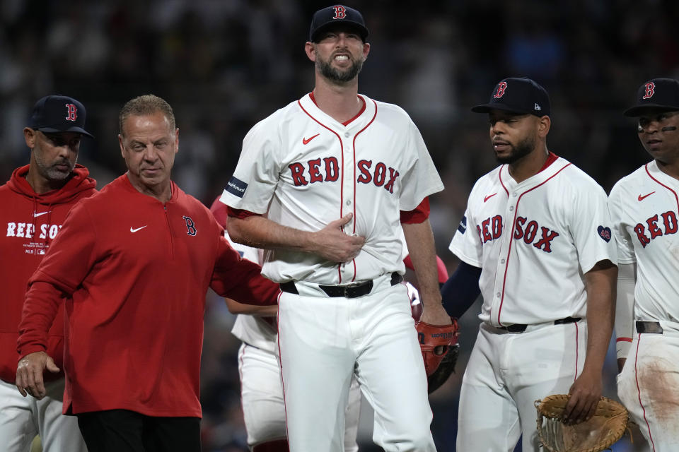 Boston Red Sox pitcher Chris Martin, center, is escorted to the dugout after fielding a line drive off the bat of Tampa Bay Rays' Josh Lowe for the final out of the top of the eighth inning during a baseball game at Fenway Park, Tuesday, May 14, 2024, in Boston. (AP Photo/Charles Krupa)