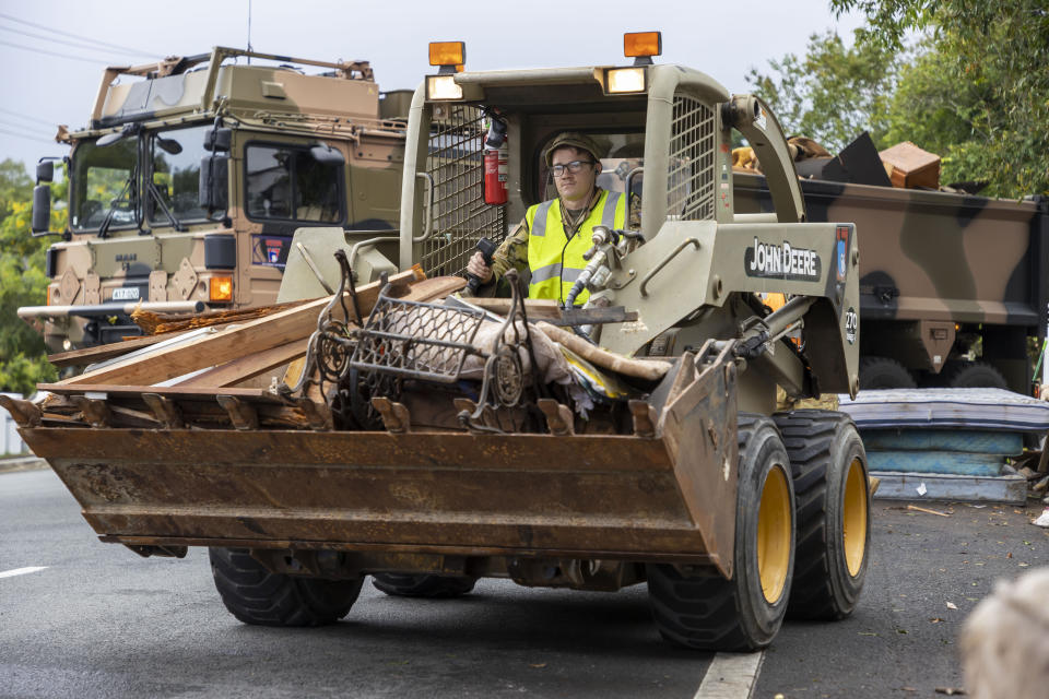 A supplied image obtained on Tuesday, March 8, 2022, of ADF personnel removing flood-damaged belongings from streets in Lismore, New South Wales.