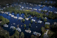 Dozens of homes are surrounded by floodwaters brought to the area by Hurricane Florence in Pender County, N.C., on Saturday, Sept. 22, 2018. The floodwaters have swallowed an estimated 25 percent of Pender county. (Kristen Zeis/The Virginian-Pilot via AP)