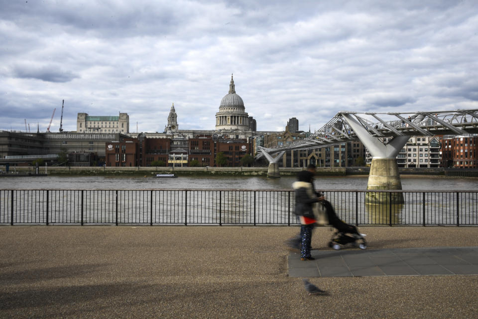 People walk on the south bank of River Thames, against the backdrop of St Paul's Cathedral, in London, Monday, Aug. 31, 2020. Today is the last day of the 'Eat out to help out' scheme, the UK Government's initiative to support restaurants, cafés, bars and pubs. (AP Photo/Alberto Pezzali)