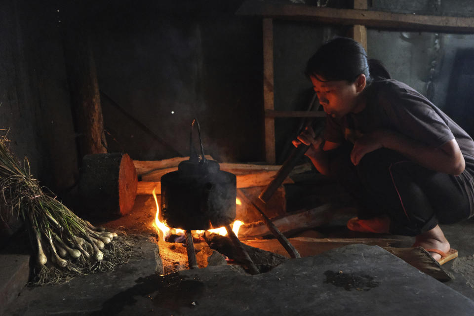 Naga girl Neichutuonuo Yhome, 23, works in the kitchen after returning from tending to her vegetable garden in Kohima, capital of the northeastern Indian state of Nagaland, Monday, June 22, 2020. Neichutuonuo and her two younger sisters decided to grow their own vegetables in the early stages of the lockdown put in place to curb the spread of the coronavirus. Their patchwork garden now has half a dozen variety of vegetables, and bean vines crawling up a bamboo trellis. (AP Photo/Yirmiyan Arthur)