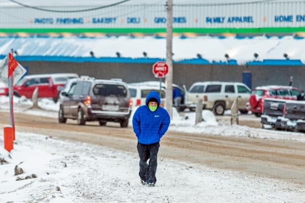 A file photo of a man wearing a mask to help slow the spread of COVID-19 in Iqaluit. On Thursday, 12 new cases were reported, along with seven recoveries. (Natalie Maerzluft/Reuters - image credit)