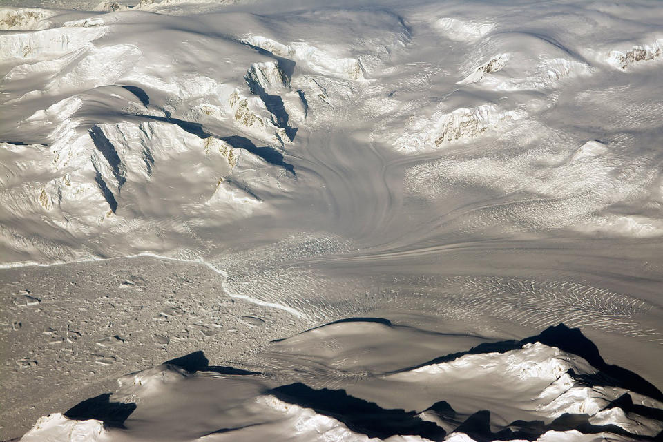 <p>Glaciers and mountains in the evening sun are seen on an Operation IceBridge research flight, returning from West Antarctica on Oct. 29, 2014. NASA is carrying out research flights over Antarctica to study changes in the continent’s ice sheet, glaciers and sea ice. The Antarctic Peninsula has been warming faster than the rest of the continent. (Photo: NASA/Michael Studinger) </p>