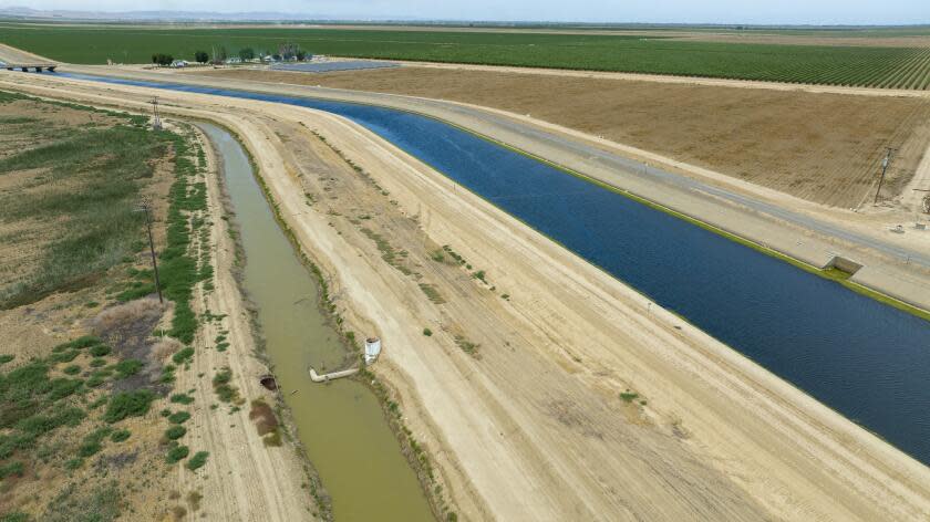 Firebaugh, CA - June 03: The Delta-Mendota Canal, right, and a parallel canal under the Panoche Water District's control, left, on Friday, June 3, 2022 in Firebaugh, CA. In April the U.S. Attorney's office charged the head of the Panoche Water District with stealing 25 million dollars worth of water out of the Delta Mendota Canal exploiting a leak in the canal where he engineered a way to steal water from the federal Central Valley Project. (Brian van der Brug / Los Angeles Times)