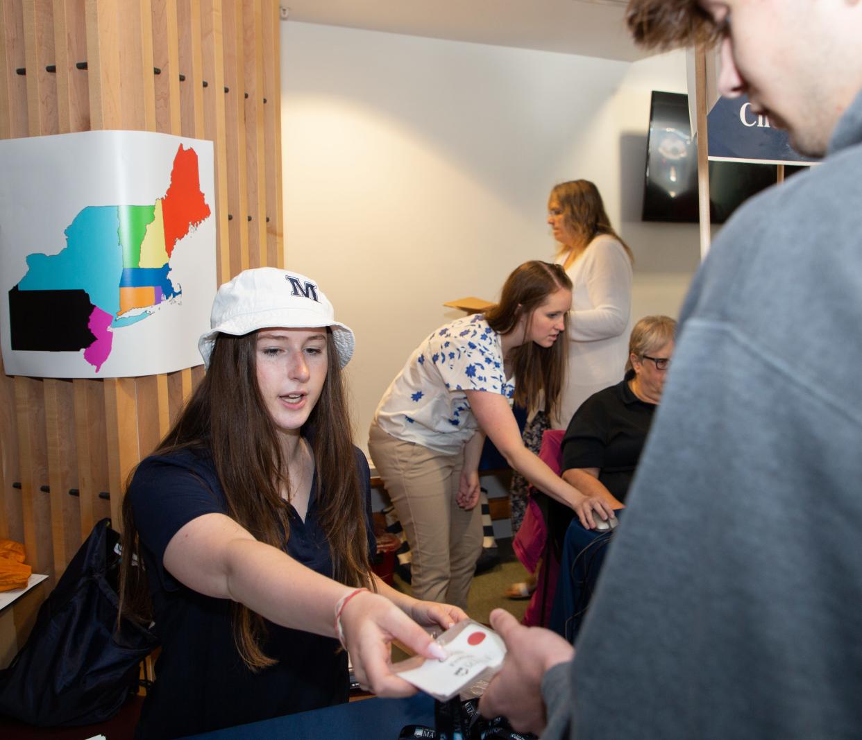 New students checking in at freshman orientation at the University of Maine get nametags are color-coded to show which state they came from among those where the university aggressively recruits.