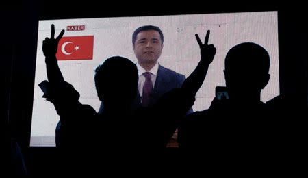 Supporters of Turkey's main pro-Kurdish Peoples' Democratic Party (HDP) watch the jailed former leader and presidential candidate Selahattin Demirtas as his first television appearance in over a year and a half is seen live on a huge screen during campaign event in Istanbul, Turkey, June 17, 2018. REUTERS/Huseyin Aldemir