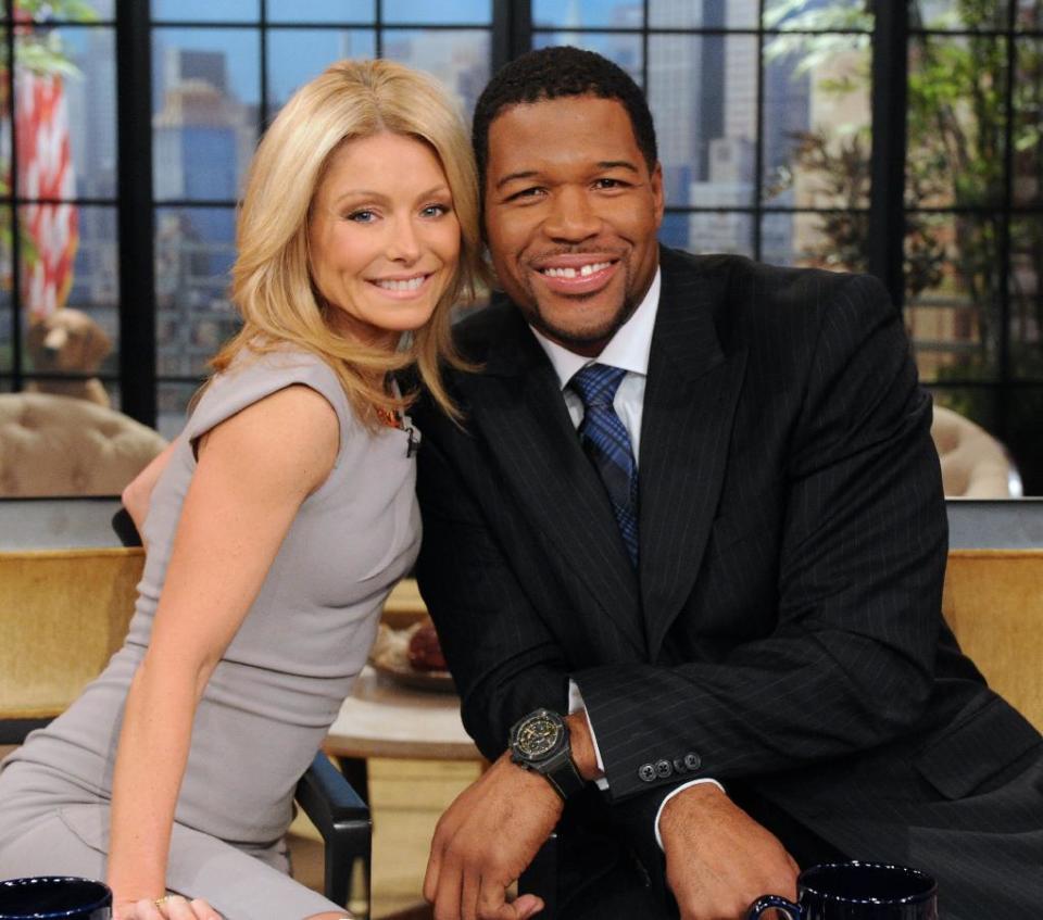 This Feb. 8, 2012 photo shows former football player Michael Strahan, right, and host Kelly Ripa during Strahan's guest-host appearance on "Live! with Kelly," in New York. Strahan is getting a permanent job in morning television as Kelly Ripa's co-host. Strahan replaces Regis Philbin on the syndicated "Live! With Kelly" show, adding his name to the title. The gap-toothed former New York Giant is currently a host of "Fox NFL Sunday." He was one of several men to get tryouts with Ripa as the show rotated several potential replacements since Philbin left last November. (AP Photo/Disney-ABC Domestic TV, Sandy SooHoo)