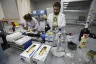 FILE - In this May 24, 2016 file photo, employees Natalya Bochkaryova, left, and Ilya Podolsky work at the Russia's national drug-testing laboratory in Moscow, Russia. Russia is accused of manipulating an archive of doping data from a laboratory in Moscow, which was meant to be a peace offering to the World Anti-Doping Agency to solve earlier disputes. (AP Photo/Alexander Zemlianichenko, file)
