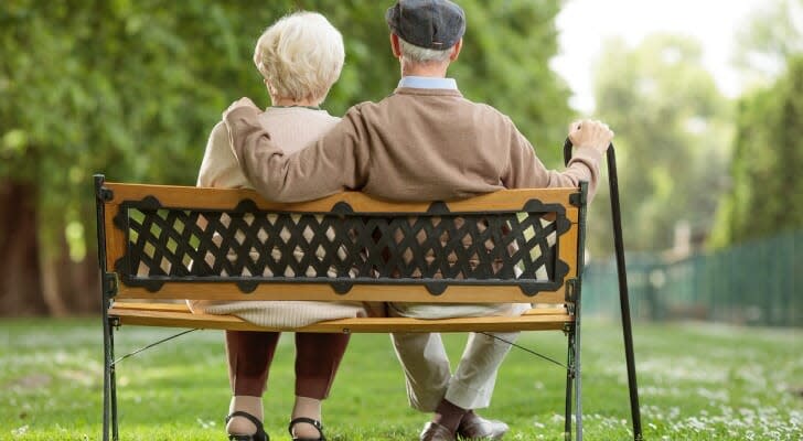 A retired couple on a park bench