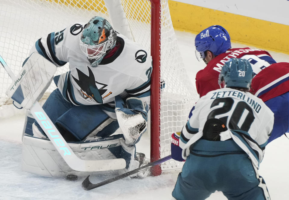 San Jose Sharks goaltender Mackenzie Blackwood (29) makes a save against Montreal Canadiens' Mike Matheson (8) as Sharks' Fabian Zetterlund (20) comes in to defend during second-period NHL hockey game action in Montreal, Thursday, Jan. 11, 2024. (Christinne Muschi/The Canadian Press via AP)