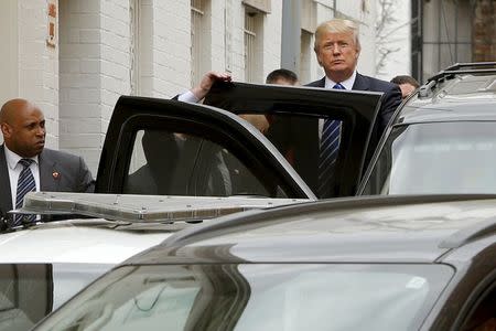 U.S. Republican presidential candidate Donald Trump waves to onlookers and reporters as he departs through a back door after meetings at Republican National Committee (RNC) headquarters in Washington March 31, 2016. REUTERS/Jonathan Ernst