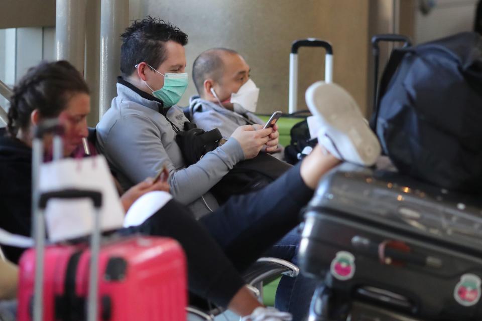 People wear masks at the international terminal at LAX airport in Los Angeles, California, U.S., amid reports of the coronavirus, March 11, 2020. REUTERS/Lucy Nicholson