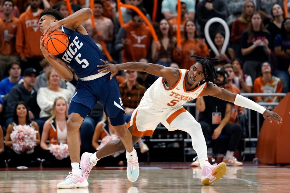 Rice guard Cameron Shelffield looks to pass while being defended by Texas guard Marcus Carr. The No. 7-ranked Longhorns improved to 8-1 with the win and will next face Stanford in Dallas on Sunday.