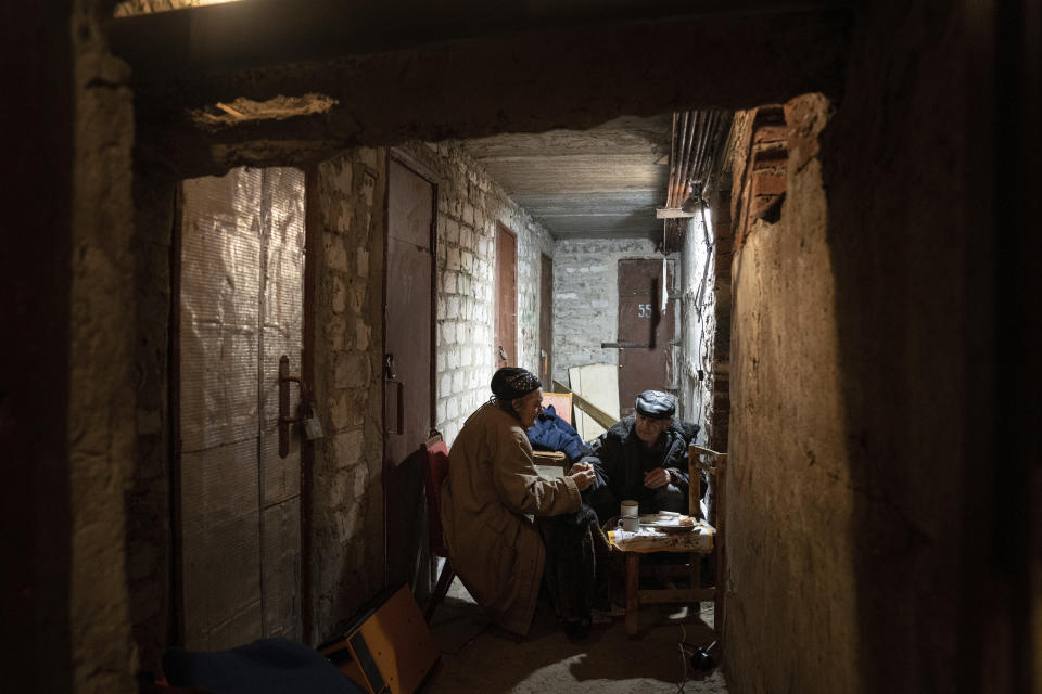 An elderly couple drinks tea in the basement of their house in Lyman, Donetsk region, eastern Ukraine, Saturday, April 30, 2022. (AP Photo/Evgeniy Maloletka)