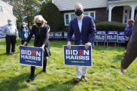 Jill Biden, front left, wife of Democratic presidential candidate former vice president Joe Biden, and Doug Emhoff, center, husband of Democratic vice presidential candidate Sen. Kamala Harris, D-Calif., place campaign placards into the ground during a campaign stop, Wednesday, Sept. 16, 2020, in Manchester, N.H. (AP Photo/Steven Senne)