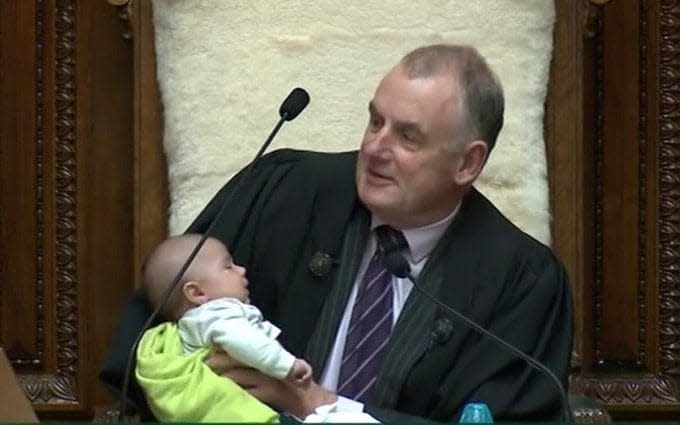 Trevor Mallard holds a Member of Parliament's baby during a parliamentary session in Wellington - REUTERS