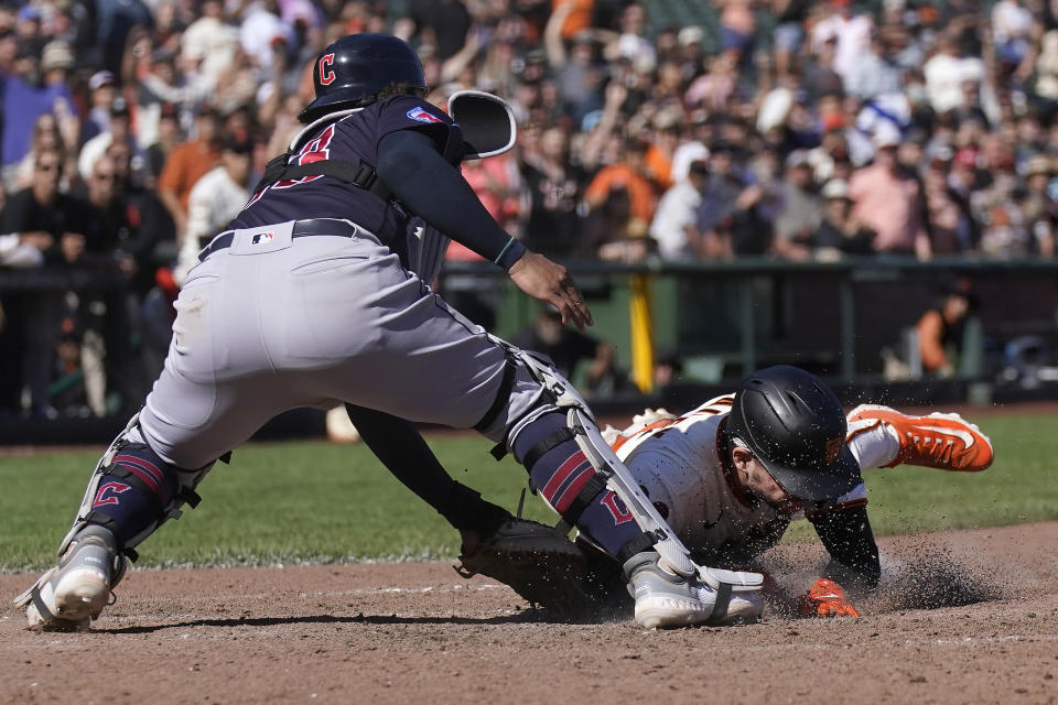 San Francisco Giants' Patrick Bailey, bottom, scores the winning run against Cleveland Guardians catcher Bo Naylor during the tenth inning of a baseball game in San Francisco, Wednesday, Sept. 13, 2023. The Giants won 6-5. (AP Photo/Jeff Chiu)