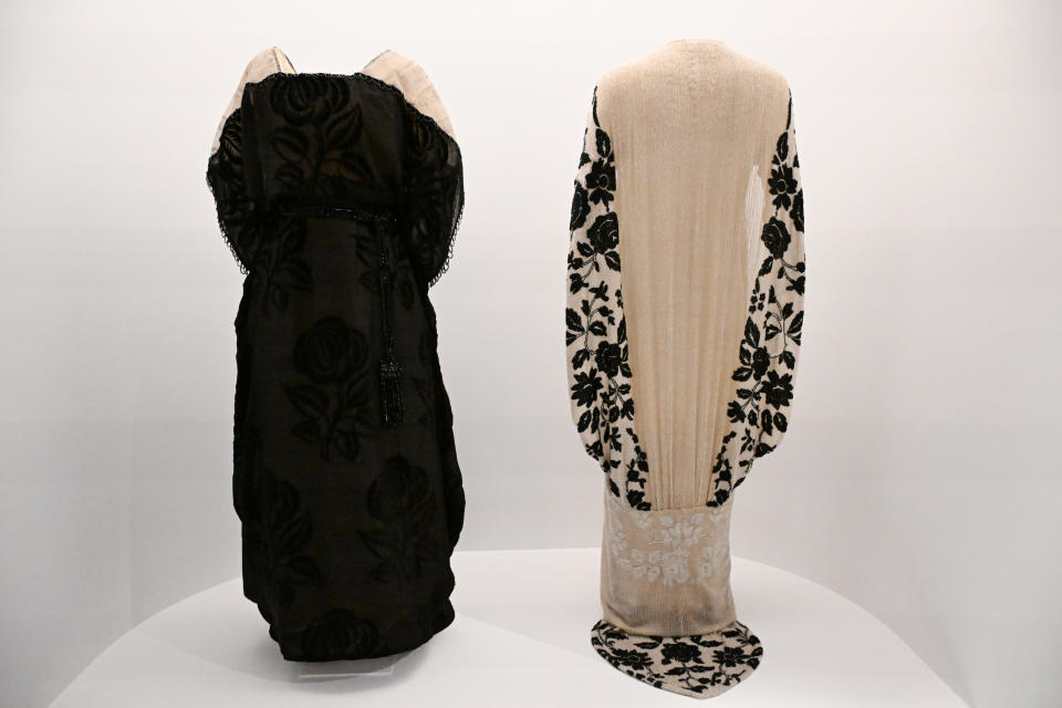 Two vintage dresses on display, one with floral patterns and one with lace detailing