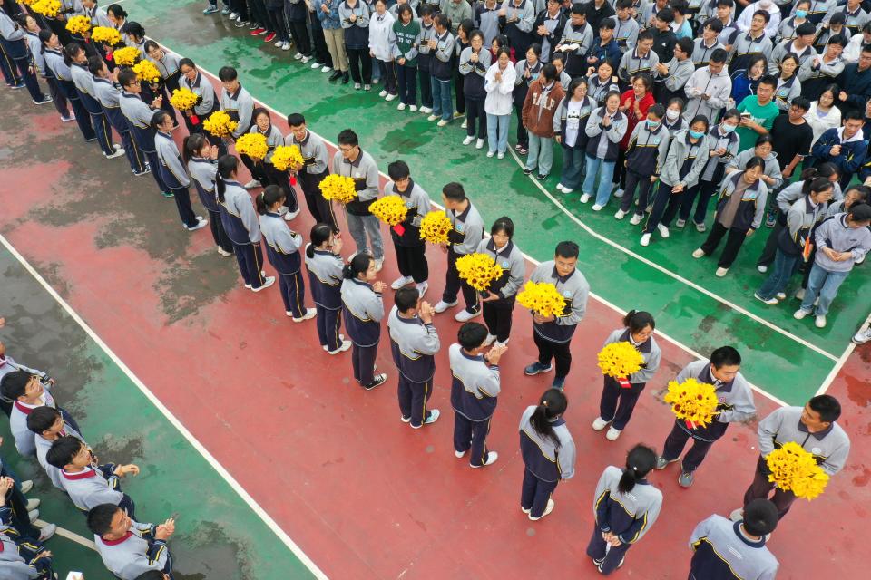 Senior 2 students give paper sunflowers to senior 3 students to cheer them up ahead of the 2023 National College Entrance Exam (aka Gaokao) at Suining Senior High School of Jiangsu on June 5, 2023 in Xuzhou, Jiangsu Province of China.