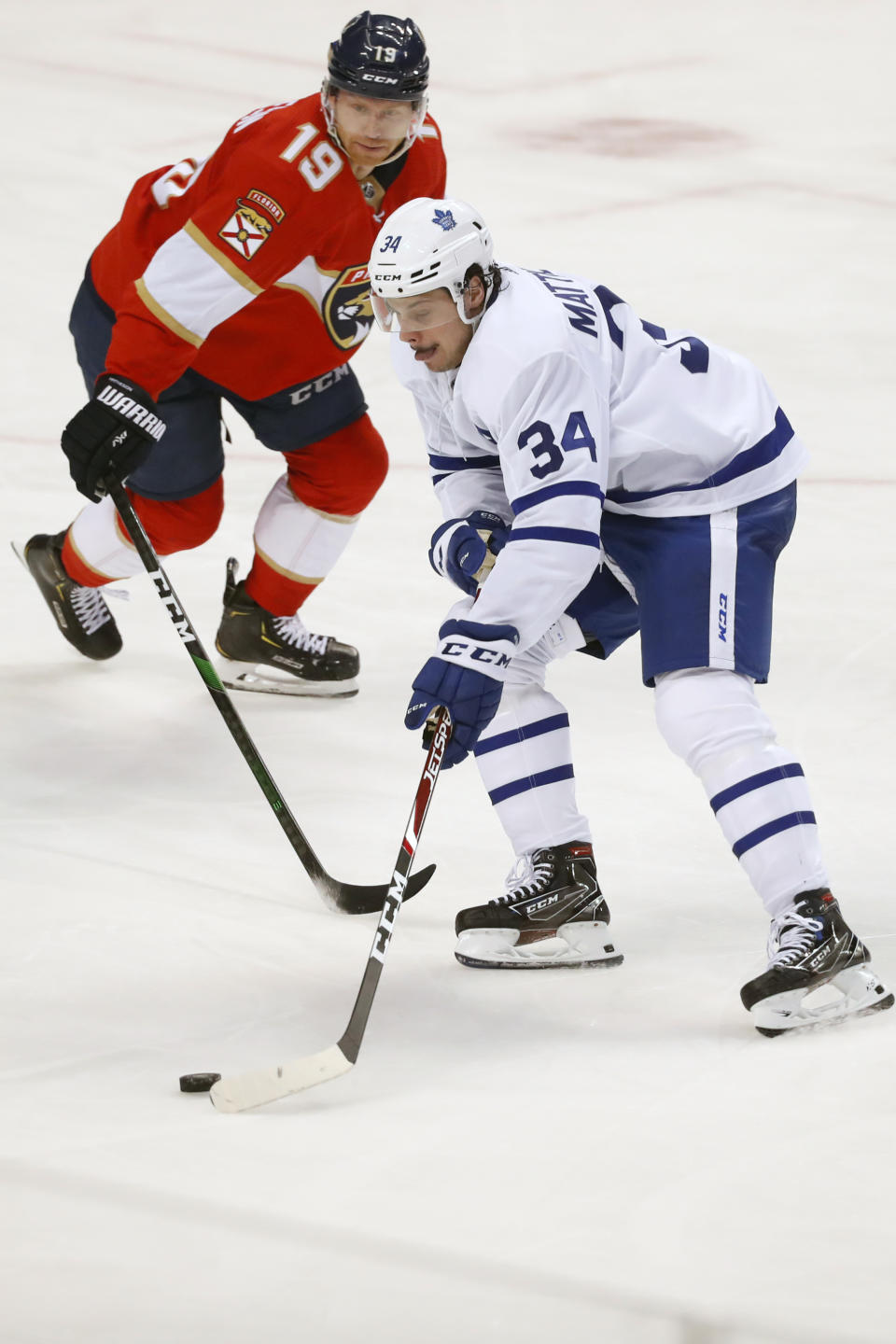 Toronto Maple Leafs center Auston Matthews (34) and Florida Panthers defenseman Mike Matheson (19) battle for the puck during the second period of an NHL hockey game, Sunday, Jan. 12, 2020, in Sunrise, Fla. (AP Photo/Wilfredo Lee)