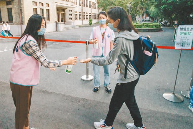 110學年度學科能力測驗22日登場，為配合防疫，試務人員在入口為考生噴灑酒精消毒。(郭吉銓攝)