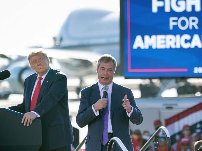 Donald Trump listens as Nigel Farage speaks
