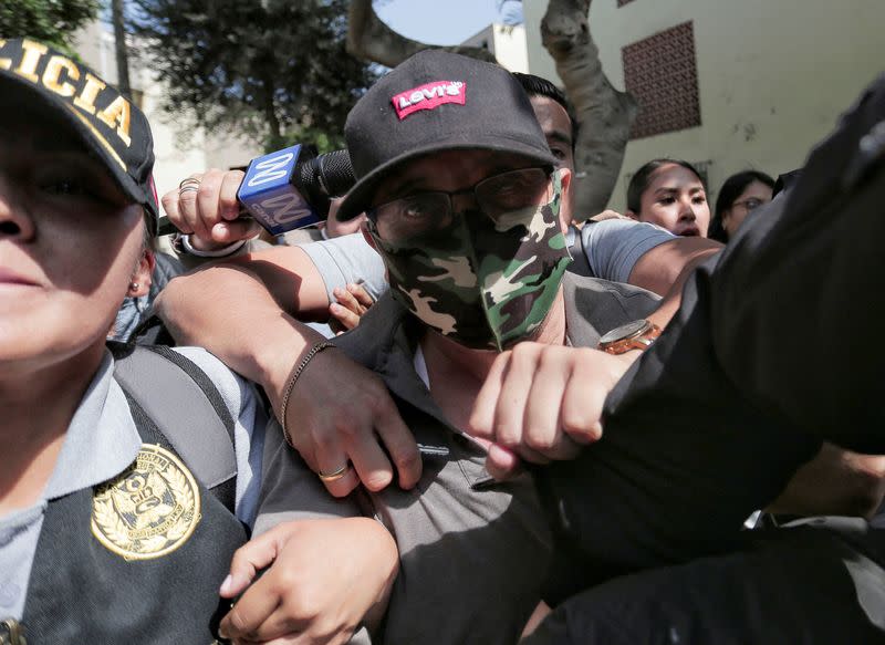 Police officers escort Nicanor Boluarte, brother of Peruvian President Dina Boluarte, in Lima