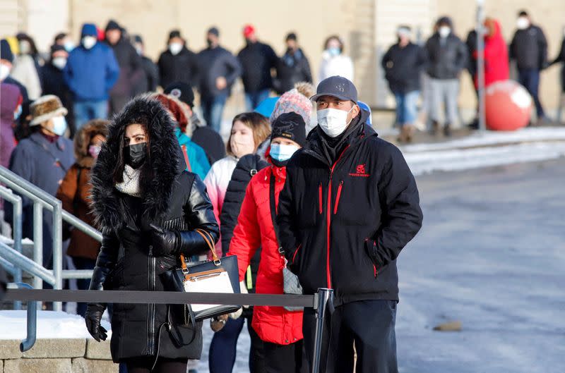 People queue to collect coronavirus disease (COVID-19) antigen test kits at the Hazeldean Mall in Ottawa