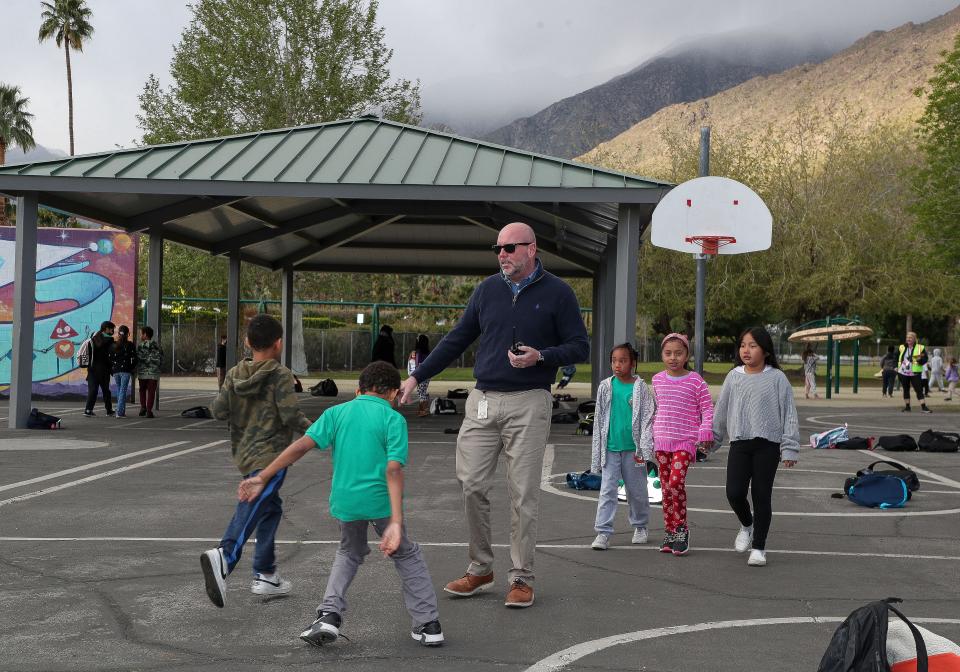 Cahuilla Elementary School principal Dr. Ryan Saunders interacts with his students as they arrive for school in the morning in Palm Springs, Calif., March 30, 2023. 