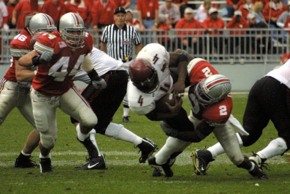 Ohio State's Mike Doss (2) puts a major hit on San Diego State's Larry Ned in the third quarter as Robert Reynolds (44) closes in.