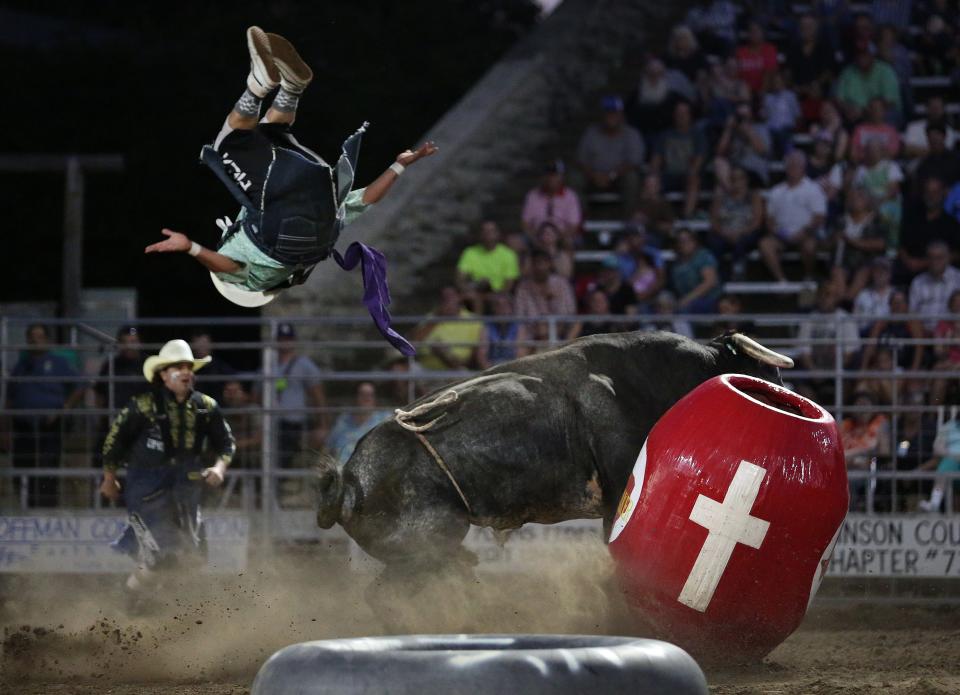 Bullfighter Blake Miller flips backward off of the barrel past the fighting bull with bullfighter Clint Lott, left, during the 76th annual Wild Bill Hickok PRCA Rodeo Bulls, Broncs and Barrels night Wednesday, Aug. 3, 2022, at Eisenhower Park in Abilene.