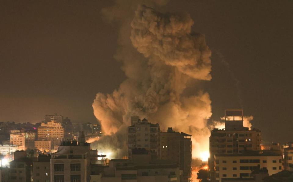 Fire and smoke rise above buildings in Gaza City during an Israeli air strike on Sunday.