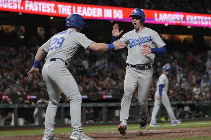 Los Angeles Dodgers' Walker Buehler, right, celebrates with Billy McKinney (29) after both scored on a double by Max Muncy during the seventh inning against the San Francisco Giants in a baseball game Wednesday, July 28, 2021, in San Francisco. (AP Photo/Tony Avelar)