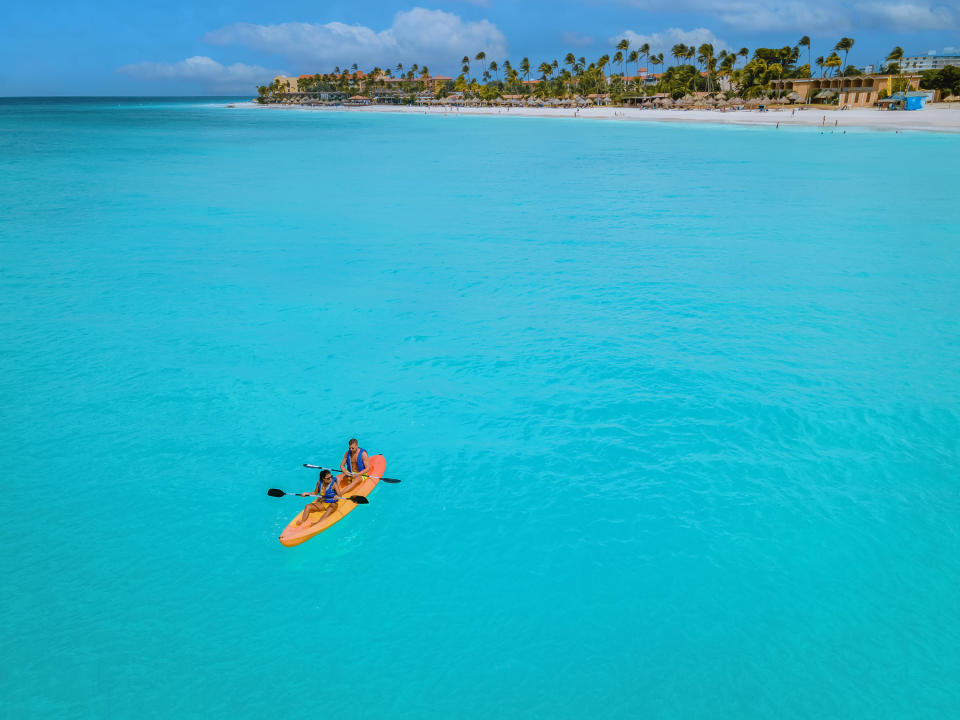 Two people kayaking in clear water far from the shore