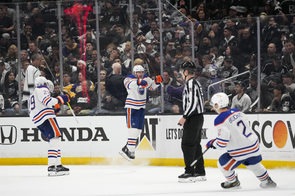 Edmonton Oilers left wing Zach Hyman (18) celebrates with center Leon Draisaitl (29) and defenseman Evan Bouchard (2) after scoring during overtime of Game 4 of an NHL hockey Stanley Cup first-round playoff series hockey game against the Los Angeles Kings Sunday, April 23, 2023, in Los Angeles. The Oilers won 5-4. (AP Photo/Ashley Landis)