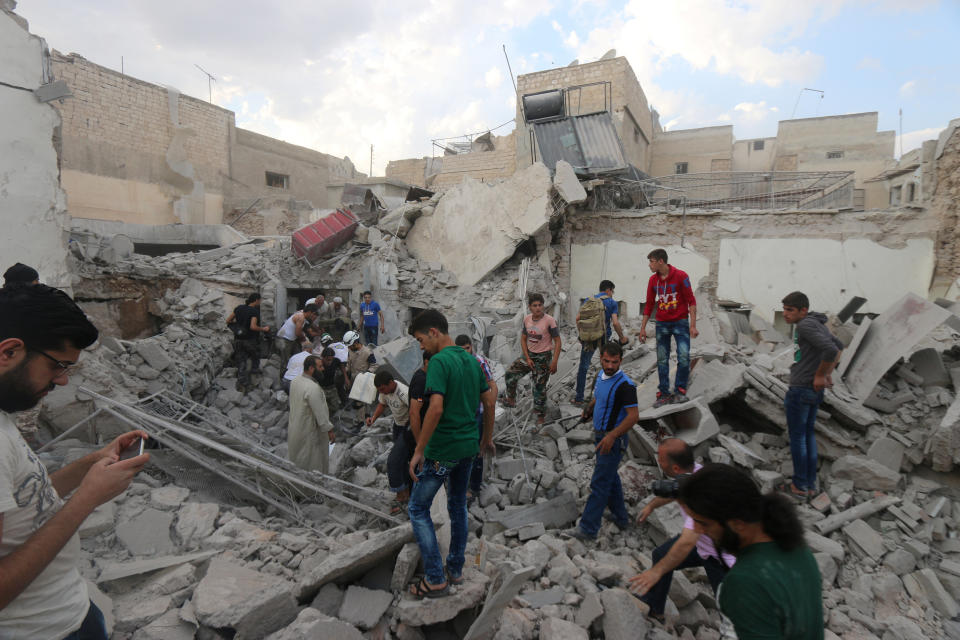 Men look for survivors under the rubble of a damaged building after an airstrike on Aleppo's rebel held Kadi Askar area, Syria on July 8, 2016.