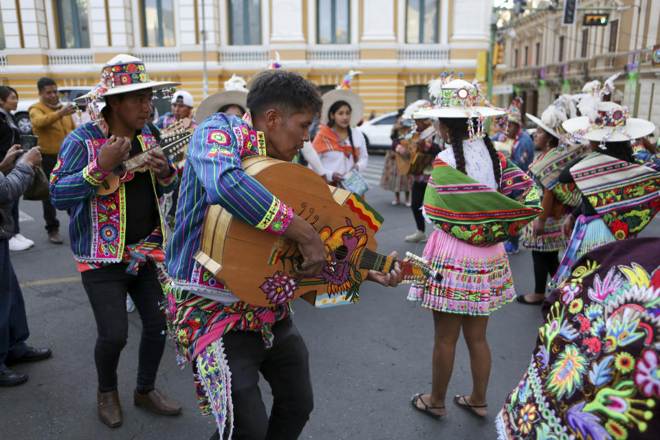 Un grupo de personas toca y baila música durante una ceremonia por el Día del Masticado de hoja de coca o "Día del Acullico," en la Plaza Murillo cerca del palacio presidencial en La Paz, Bolivia, el jueves 11 de enero de 2024. (AP Foto/José Lavayén)