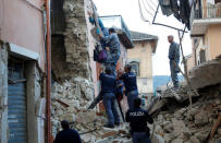 A woman is helped to leave his home by rescuers following a quake in Amatrice, central Italy, August 24, 2016. REUTERS/Remo Casilli