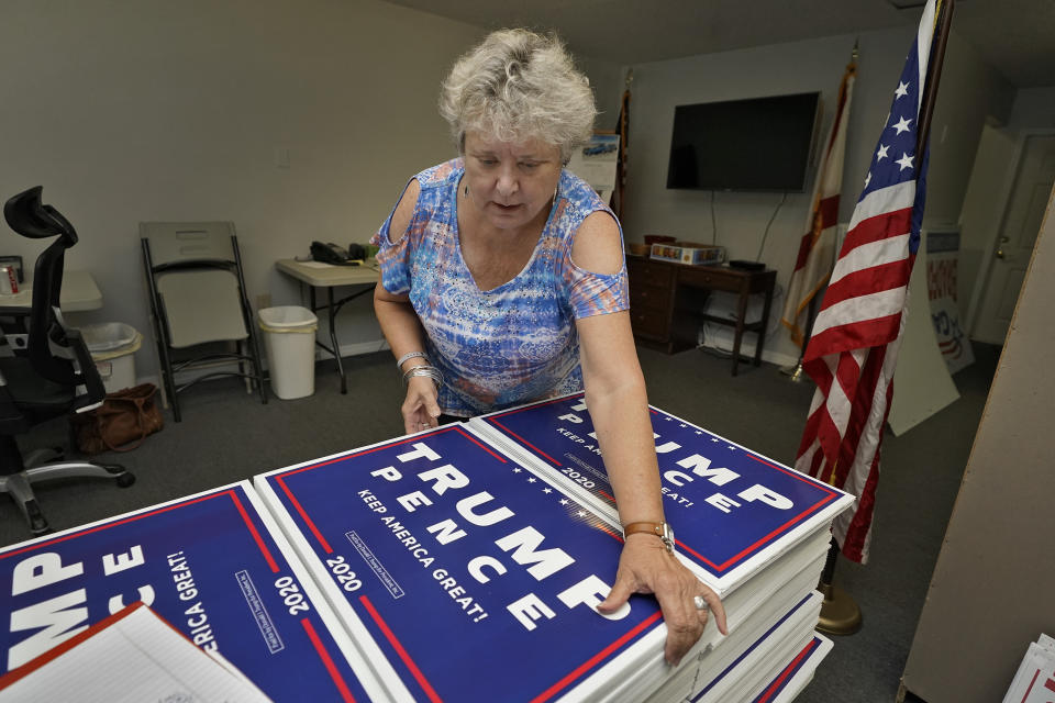 FILE - In this Tuesday, Sept. 8, 2020 file phto, Pamela Allen organizes Trump-Pence campaign signs at the Pasco county GOP headquarters in Hudson, Fla. Allen, who worked as a poll watcher in Pasco County, said she saw no problems on Election Day. “Here in Pasco I have to admit it was very well done,” she said. But she believes things she's seen on the conservative Donald Trump-favored Newsmax about alleged voter fraud in other states. (AP Photo/Chris O'Meara)