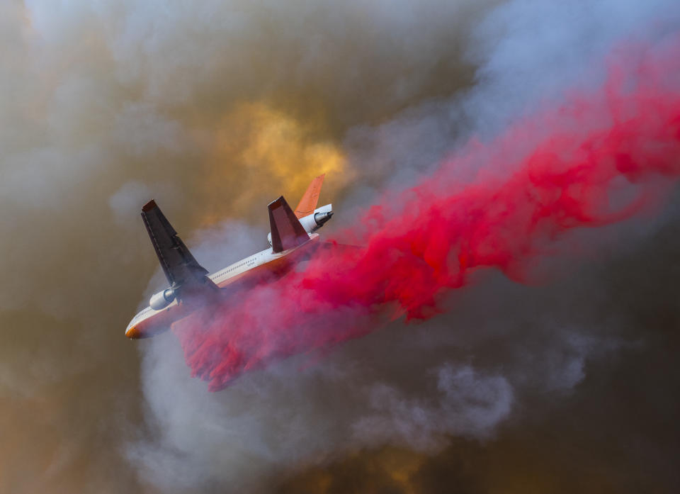 The DC-10 VLAT, or Very Large Air Tanker, makes a drop between Santiago Canyon Road and Cowan Heights while trying to slow the spread of the Canyon Fire 2 in Anaheim Hills, California.