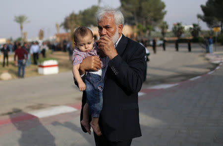 The son of Palestinian engineering lecturer Fadi al-Batsh, who was shot dead in Malaysia, is held by his grandfather upon his father's body arrival in the southern Gaza Strip April 26, 2018. REUTERS/Ibraheem Abu Mustafa