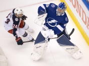 Tampa Bay Lightning goaltender Andrei Vasilevskiy (88) clears the puck under pressure from Columbus Blue Jackets center Nathan Gerbe (24) during the first period in Game 1 of an NHL hockey Stanley Cup first-round playoff series, Tuesday, Aug. 11, 2020, in Toronto. (Frank Gunn/The Canadian Press via AP)