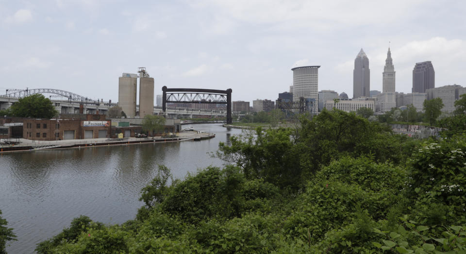 The Cuyahoga River winds it way toward Cleveland, Tuesday, May 28, 2019. Fifty years after the Cuyahoga River's famous fire, a plucky new generation of Cleveland artists and entrepreneurs has turned the old jokes about the “mistake on the lake” into inspiration and forged the decades of embarrassment into a fiery brand of local pride. (AP Photo/Tony Dejak)